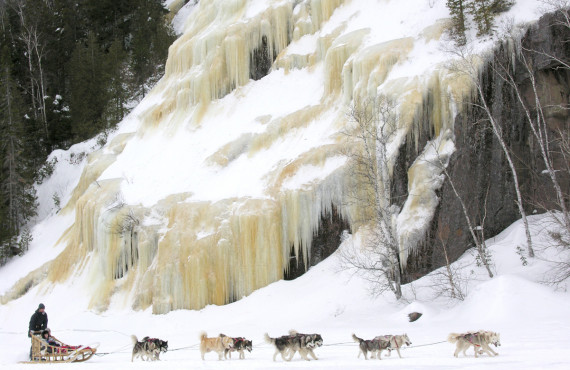 En traîneau à chiens longeant un mur de glace